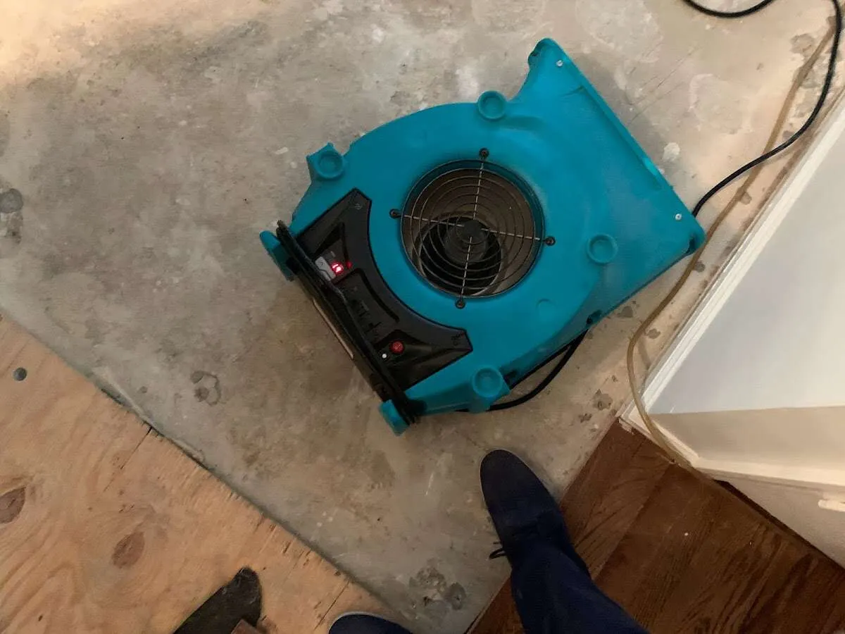 Air mover drying subfloor during Leak Detection & Repair in Hampden